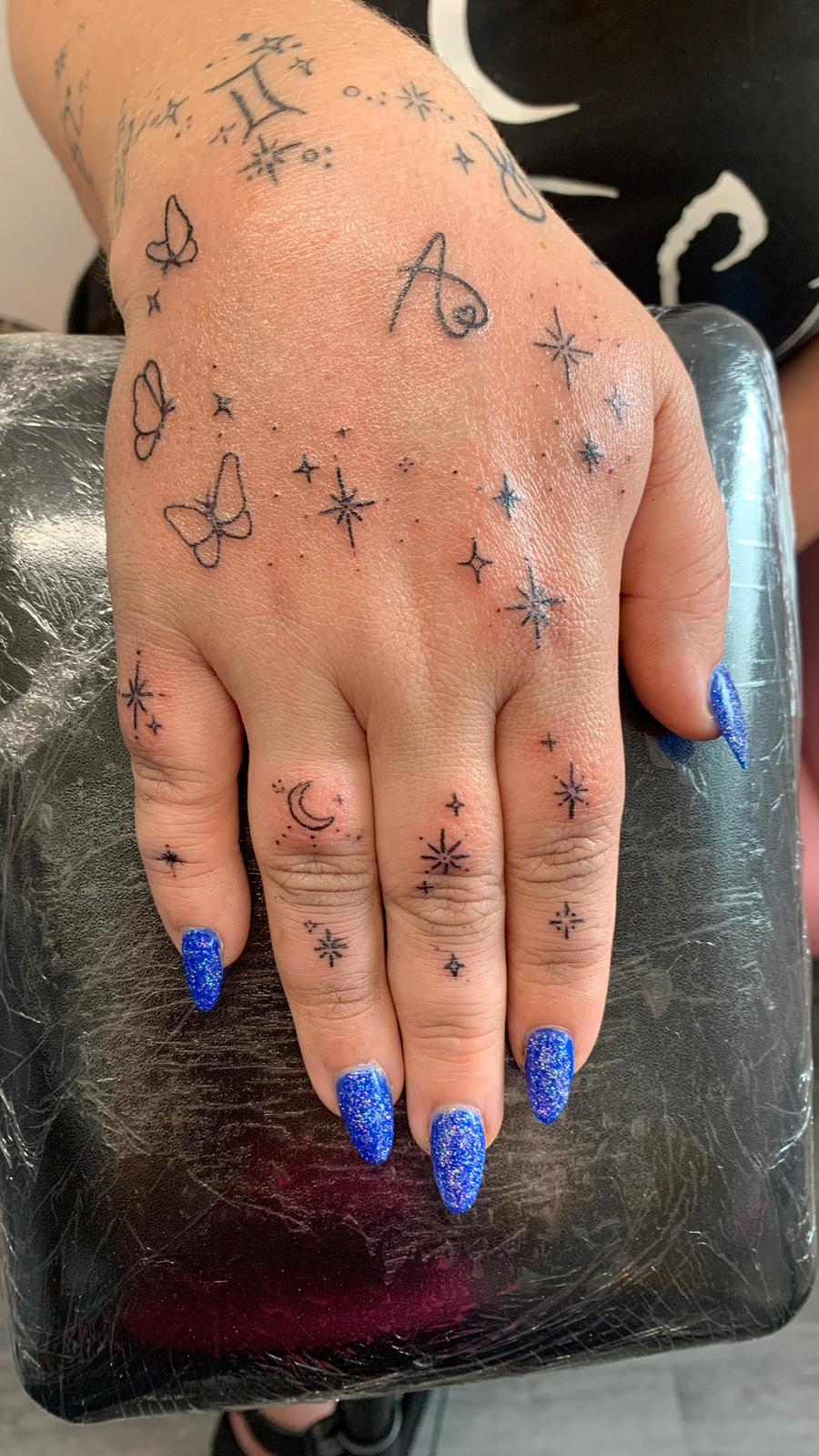 Tiny fine line flower tattoo Merseyside